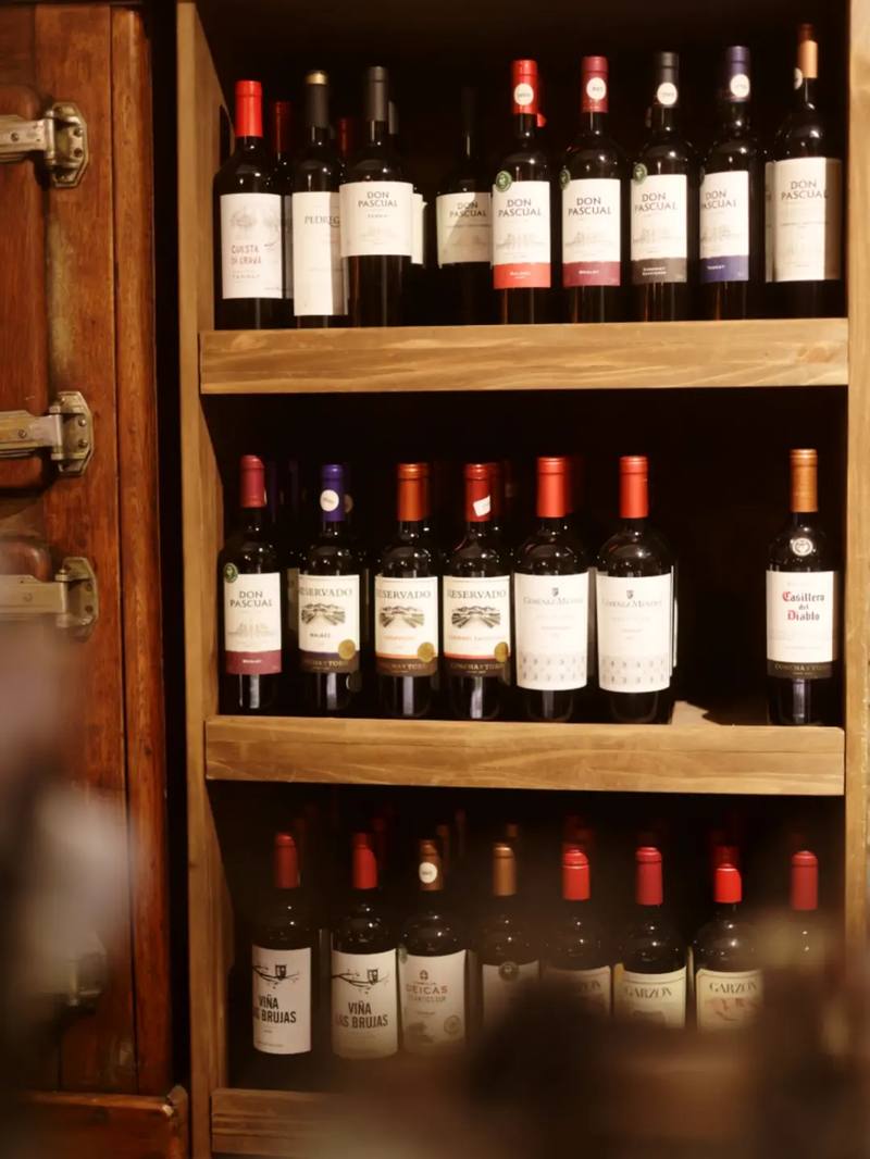 Estantes de madera de la cava con botellas de vino tinto